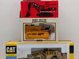 two boxed boxes of toy construction vehicles on a white surface