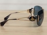 sunglasses on a wooden table with a white wall in the background