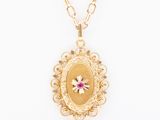 un collier Locke en or avec une pierre rose entourée d'une chaîne