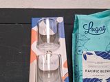 a glass of water next to a package of coffee beans and a packet of coffee beans