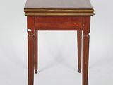 a small wooden table with a leather top on a white background
