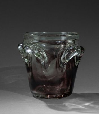 un vase en verre muni d'une anse, posé sur une table