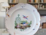 une assiette sur laquelle est représenté un oiseau, posée sur une table