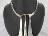 une photo d'un collier en argent sur un mannequin noir