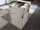 a printer sitting on top of a cart on the floor