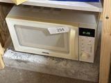 un micro-ondes posé sur une étagère dans une pièce