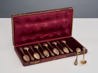 six cuillères dans un étui posé sur une table