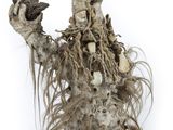 a sculpture of a man with long hair holding a bird