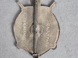 a picture of a silver pin with a sword on it