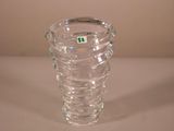 un vase en verre transparent sur lequel est collé un autocollant vert