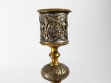 an antique brass candle holder with a decorative design on the base