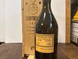 une bouteille de vin posée sur une table à côté d'une caisse en bois
