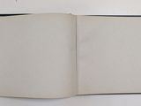 an open book on a white surface with a black border
