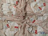 a lot of clothes with price tags on them on a bed