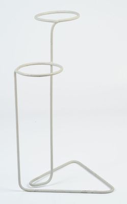 the white metal stand is holding a glass of water