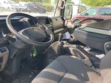a car with a steering wheel and a water bottle in the passenger seat
