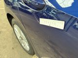 a blue car parked in a parking lot with a sticker on the door