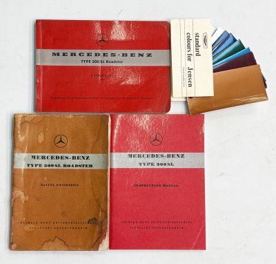trois livres sont posés les uns à côté des autres sur une surface blanche