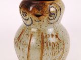 a small ceramic vase with an owl design on it