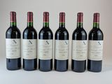 six bouteilles de vin sont alignées sur une table