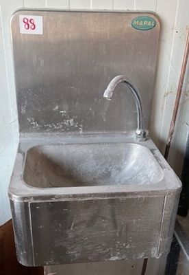 a sink in the corner of a room with a faucet
