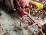a red tractor that is parked next to a yellow tractor