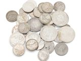 une pile de vieilles pièces d'argent sur une surface blanche