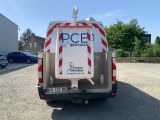 the back end of a white van with a red and white stripe on it