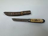 two knives are sitting next to each other on a white surface