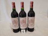 trois bouteilles de vin rouge sont posées sur une nappe blanche