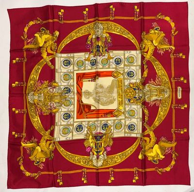 a close up of a red and gold scarf with a picture on it