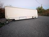 a white trailer that is parked on the side of the road