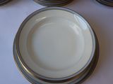 a white plate with a gold rim sitting on a table