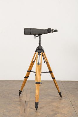 an image of a tripod on a wooden floor with a white wall in the background