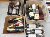 de nombreuses bouteilles de vin rangées dans des cartons posés par terre