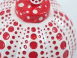 a red and white vase with polka dots on it