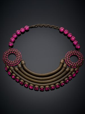 un collier rose et doré orné de pierres roses sur fond noir