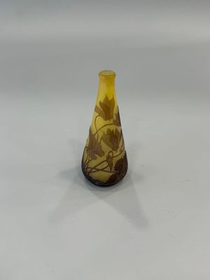 vase en verre jaune avec un socle marron sur un fond blanc