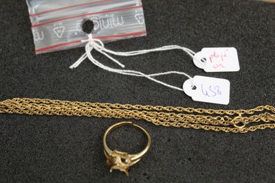 a gold ring and a gold chain on a table