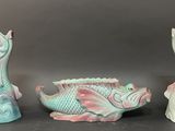 three figurines of fish sitting on a table