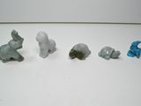 cinq petites figurines d'animaux sur un fond blanc