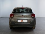 the back of a silver car in a room with a white wall