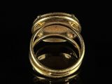 a close up of a gold ring on a black surface