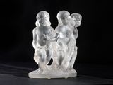 figurines of three children on a marble base against a black background