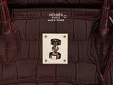 the handle of a brown purse with a metal button on it