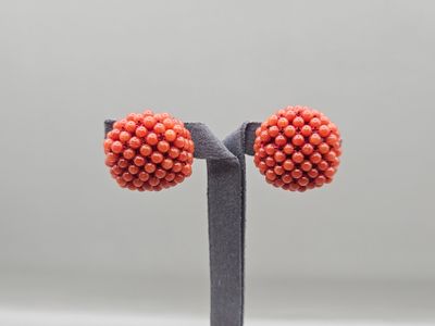 a close up of a pair of orange beaded earrings