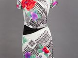a white dress with colorful flowers on it on a mannequin