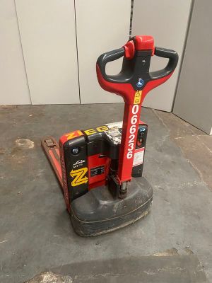 une photo d'une machine rouge et noire posée sur un sol en béton