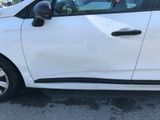 a small white car parked in a parking lot