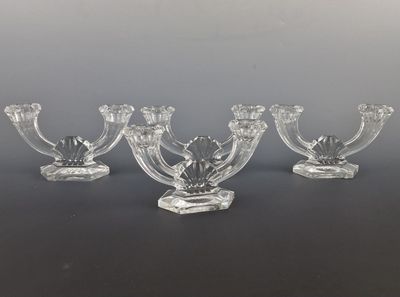 quatre bougeoirs en verre posés sur une surface noire